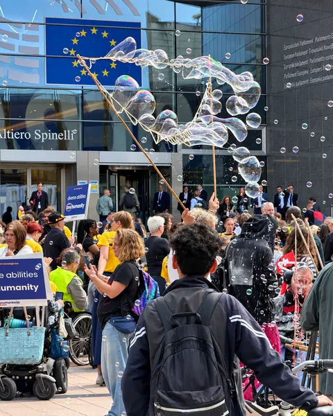 Bolle di sapone e magliette gialle davanti al Parlamento europeo.